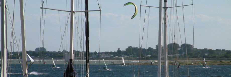 Blick über den Yachthafen Großenbrode auf die Windsurfer und Kitesurfer im Hafenbecken